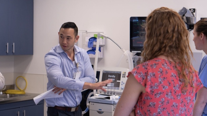 A physician teaching residents at the bedside