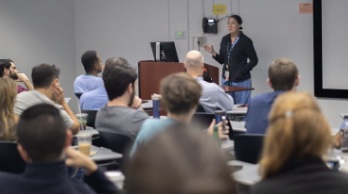 A physician presenting to a lecture hall of learners
