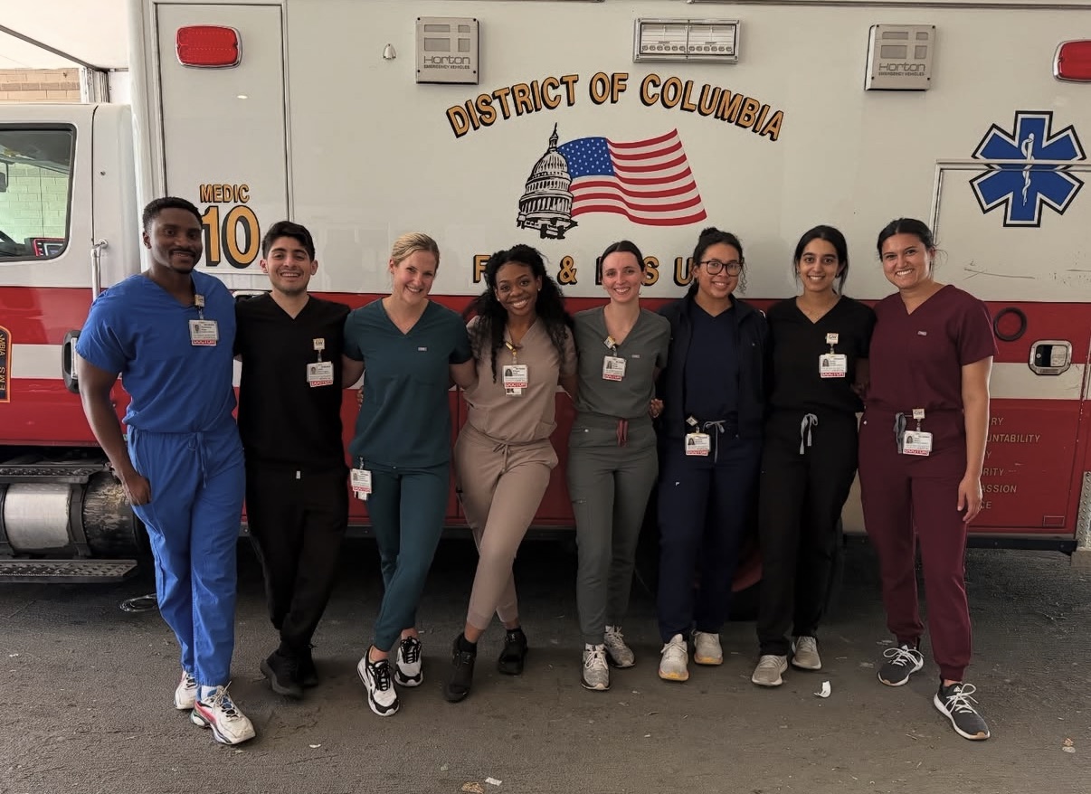 AEMP clinicians posing together in front of a DC Fire and EMS ambulance